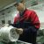 Daniel Lee, Product Engineer at KCVents, inspecting an inline duct fan on the factory production line.